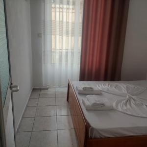 um quarto com uma cama e uma janela com toalhas em Hostel Casa Mia SR em Saranda