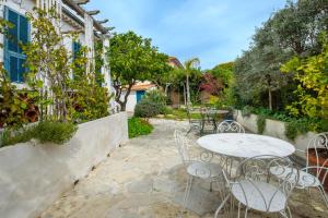 een patio met een tafel, stoelen en bomen bij Maison avec studio Cros de Cagnes in Cagnes-sur-Mer
