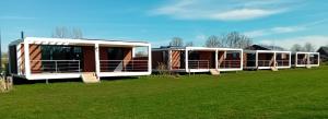 una fila de casas modulares en un campo en Antonius Hoeve Chalets en Oudenbosch