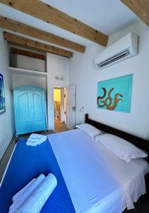 a bedroom with a large bed with blue sheets at Villa Iole in Casale Azara
