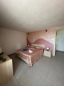 ノーヴァ・シーリにあるAppartamento La Petrosaのベッドルーム1室(ベッド1台付)が備わります。壁には絵画が飾られています。