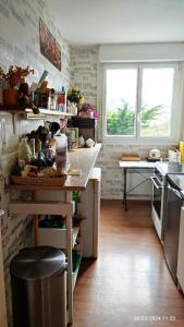 una cocina con encimera y mesa. en Chambre Rafaël chez particulier en Cherburgo