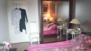 una camera con specchio e letto e spogliatoio di Chambre Rafaël chez particulier a Cherbourg en Cotentin
