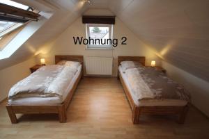 two beds in a attic room with a window at Ferienwohung Weinheim in Weinheim