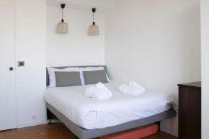 un letto bianco con due asciugamani bianchi di Balcony, 2 Rooms, View of Eiffel Tower, 60m² a Boulogne-Billancourt