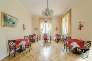 HOTIDAY Hotel Rapallo في رابالو: غرفة طعام بها طاولات وكراسي وثريا