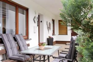 un patio con mesa y sillas en un porche en Ferienwohnung Hengemes, 45qm, en Medebach