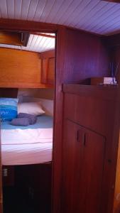 a small bunk bed in a boat with a cabinet at PIAM - Boat House in Faro