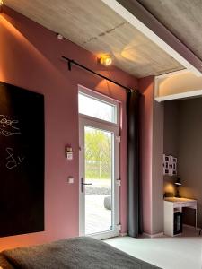 a bedroom with pink walls and a sliding door at Guestroom by "FARBGESTALT" in Sarstedt
