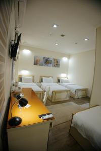 um quarto com quatro camas e uma secretária em Like INN Hotel em Samarkand