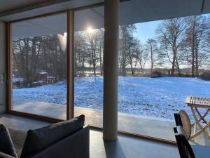 a living room with a view of a snow covered yard at See-h-Stueck in Himmelpfort
