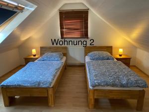 two twin beds in a room with a window at Ferienwohung Weinheim in Weinheim