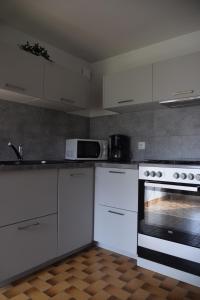 a kitchen with white cabinets and a stove at Jolie maison de campagne rénovée en 2022 in Langueux