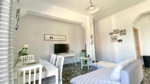 a white living room with a table and a tv at Ammos beachfront apartment! in Kardamaina