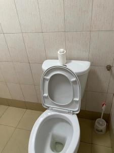 a toilet with a roll of toilet paper on the seat at Life Lounge Guest house in Mbarara