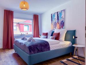 a bedroom with a blue bed and a window at UPPER ROOM Apartment im Zentrum mit kostenfreiem Parkplatz in Neustadt an der Weinstraße