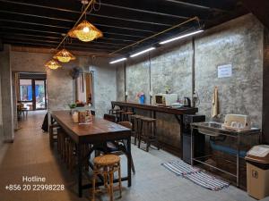 un restaurante con mesas y sillas de madera y una barra en STAY Hostel & Motorbike Rental - Thakhek en Thakhek
