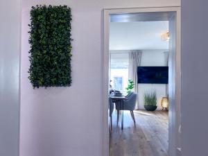 a living room with a table and a plant on a wall at UPPER ROOM Apartment im Zentrum mit kostenfreiem Parkplatz in Neustadt an der Weinstraße