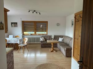 a living room with a couch and a table at Gästehaus Rachelblick in Frauenau
