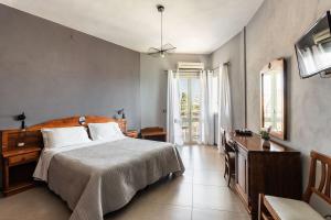 a bedroom with a bed and a desk and a television at B&B La terrazza sul mare in Avola