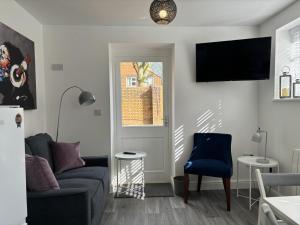 - un salon avec un canapé et une télévision murale dans l'établissement Hartshorne House, à Telford
