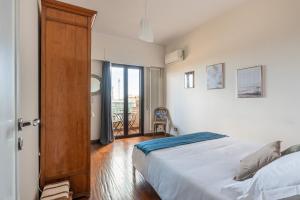 a bedroom with a bed and a door with a balcony at Casa Panoramica dei Mille by Wonderful Italy in Palermo