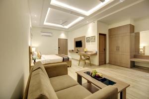 Hotel Aerotech Near Delhi Airport في نيودلهي: غرفة معيشة مع أريكة وسرير