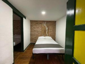 a bed in a room with a brick wall at BOSQUE DE NIEBLA in Pijao