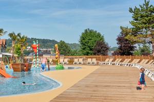 a group of children playing in the pool at a resort at Camping La Vallée - Roan in Houlgate