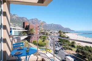 a balcony with a blue table and a view of the beach at Modoco in Cape Town