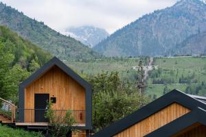 a house in the mountains with a balcony at Qazaq Auyl Eco Hotel in Almaty