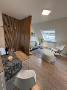 un soggiorno con un divano, un tavolo e delle sedie di Nordic Charme by B&B a Bad Gandersheim