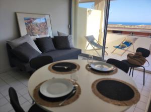 a living room with two tables and a couch at Appartement Vue bleu azur in Sète