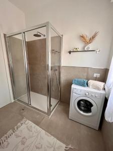 a bathroom with a shower and a washing machine at Casa blu relax in Garda