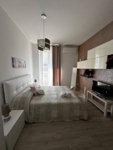 a white bedroom with a bed and a television at Bella Puglia Bed and Breakfast in Ruvo di Puglia +10 photos