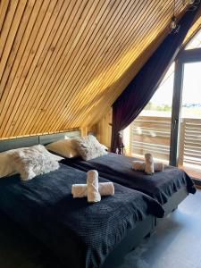 dwa łóżka z ręcznikami na górze w sypialni w obiekcie Stodoła Na Kresach - widokowy domek drewniany, całoroczny JACUZZI & SAUNA w mieście Bodzentyn