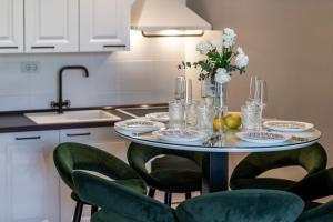 stół z zielonymi krzesłami i wazon kwiatów w obiekcie Apartment Barbara with Private pool w Dubrowniku