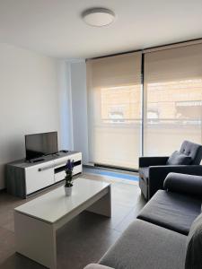 a living room with a couch and a tv at Apartamentos CorteInglés Castellón in Castellón de la Plana