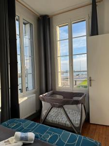 ル・アーヴルにある"L'amarrage" 2 chambres Perret Pleine Vue Merのベッド1台、景色を望む窓が備わる客室です。