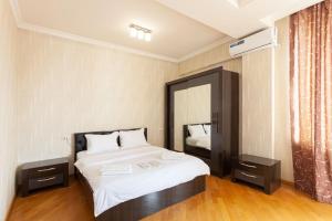 een slaapkamer met een groot bed en een spiegel bij Stay Inn apartments at Buzand 13 street in Jerevan