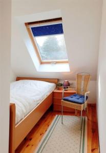 a bedroom with a bed and a window and a chair at Anemone - a74326 in Mirow