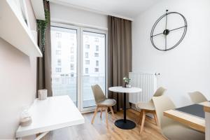 a white apartment with a table and chairs and a window at Walerego Sławka Cosy Studio in Krakow