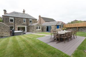 a patio with a table and chairs in a yard at Aitken House in Thurlstone