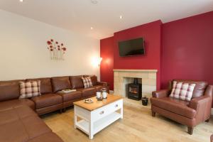 a living room with a couch and a fireplace at Aitken House in Thurlstone