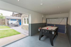 a room with a ping pong table and a patio at Aitken House in Thurlstone