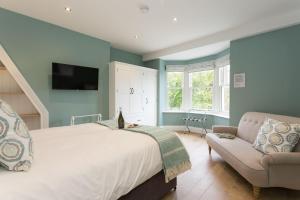 a bedroom with a large bed and a couch at Aitken House in Thurlstone