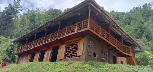 a building with a balcony on top of a hill at Higland Homestay Bac Ha in Bắc Hà