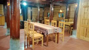 a dining room with a table and wooden chairs at Higland Homestay Bac Ha in Bắc Hà