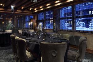 uma sala de jantar com uma mesa longa e cadeiras em Hotel Le Saint Roch em Courchevel