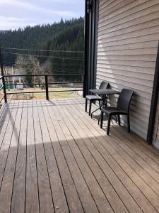 eine Terrasse mit zwei Bänken und einem Tisch auf einer Terrasse in der Unterkunft Небокрай in Poljanyzja